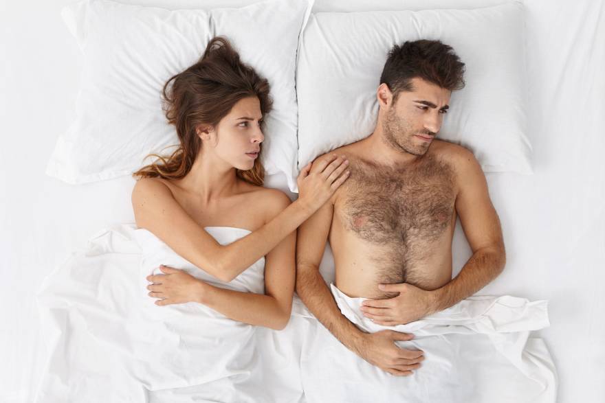 nesrecnan muskarac u krevetu sa zenom koja ga tesi