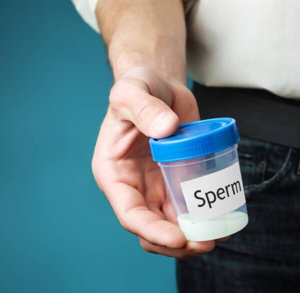 Čovek drži bočicu sa spermom